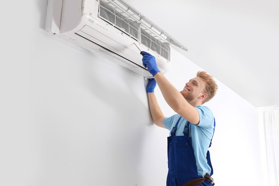 Kältetechniker installiert eine Klimaanlage an der Wand